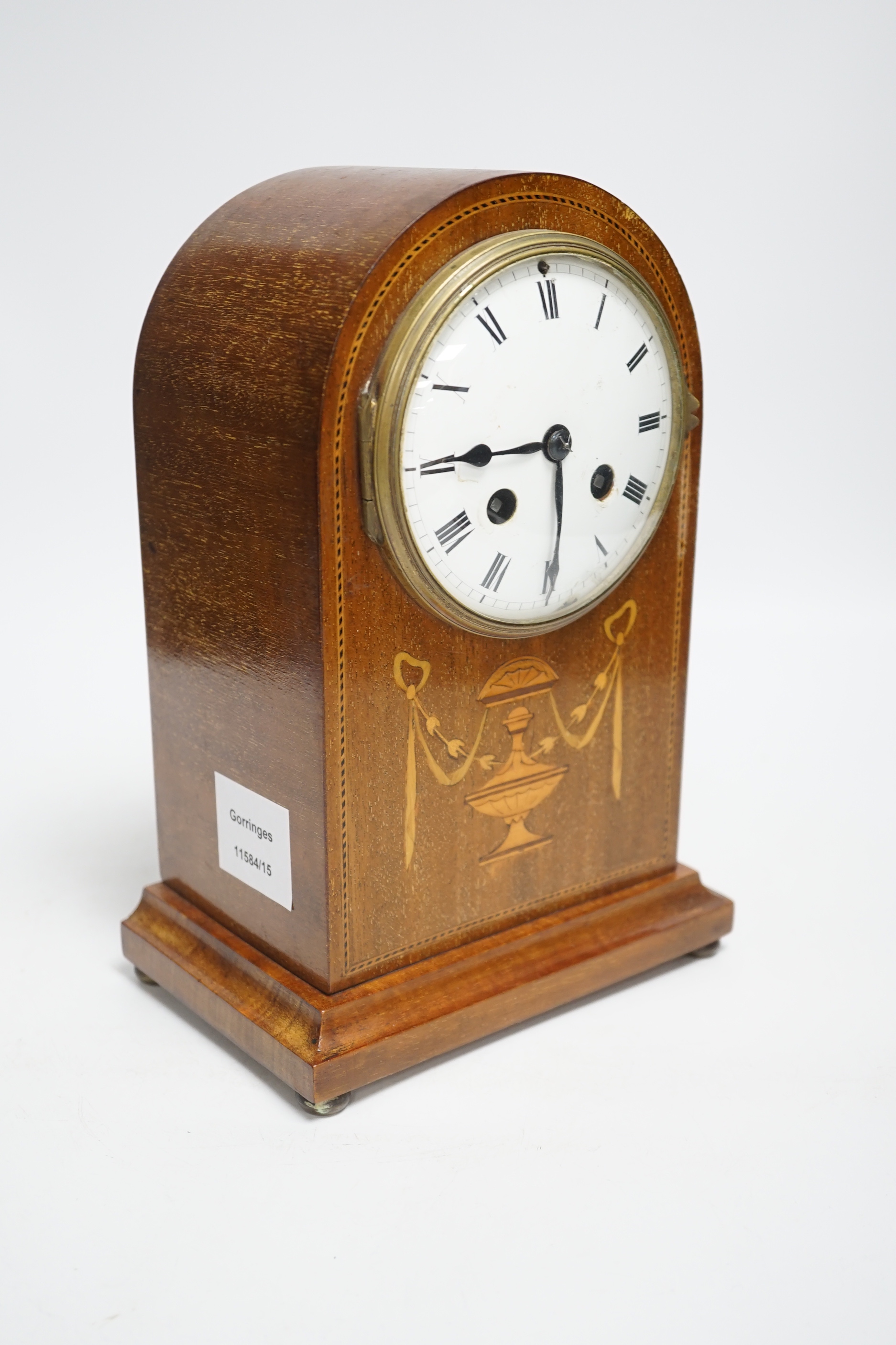 An Edwardian marquetry mantel clock with enamel dial, the case inlaid with swags, 26cm high